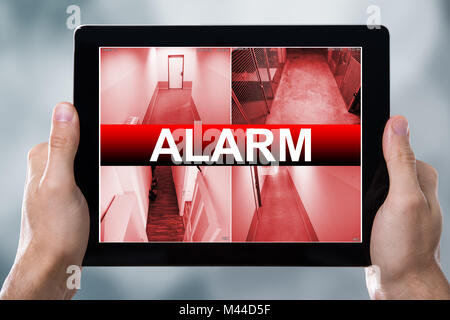 Close-up Of A Person With Digital Tablet Showing Alarm Text On Screen Stock Photo