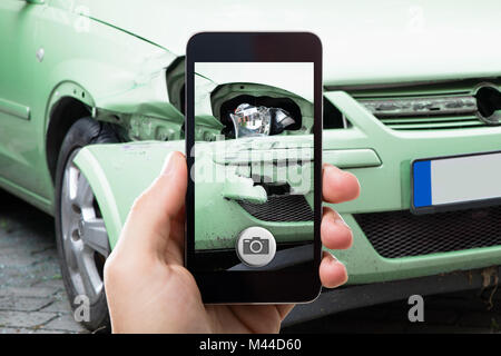 Close Up Of A Hand Taking Photo Of Car Accident Through Smartphone Stock Photo