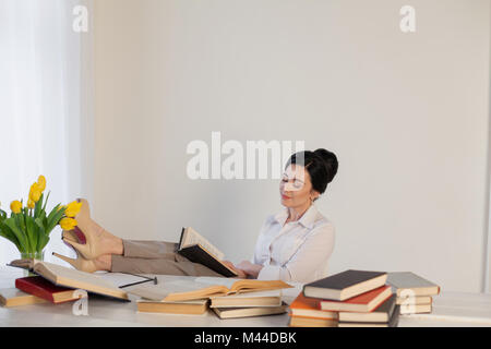 beautiful girl reads books at the table preparing for the exam Stock Photo