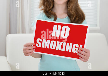 Close-up Of A Girl Holding Banner Showing No Smoking Text Stock Photo