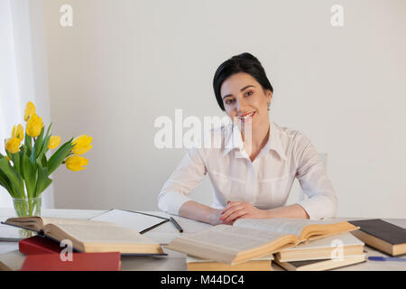 beautiful girl reads books at the table preparing for the exam Stock Photo