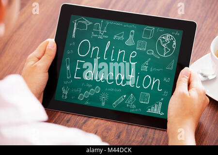 Elevated View Of A Person Holding Digital Tablet Showing Online Education Stock Photo