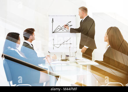 Double exposure of businessman explaining line graph to colleagues Stock Photo