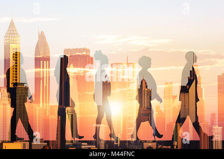 Double exposure of silhouette business people and modern buildings during sunset Stock Photo