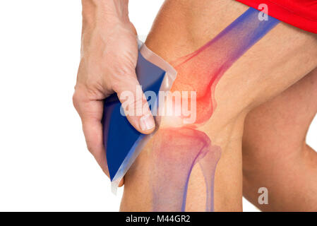 Midsection of man holding cool gel pack on knee for pain relief over white background Stock Photo