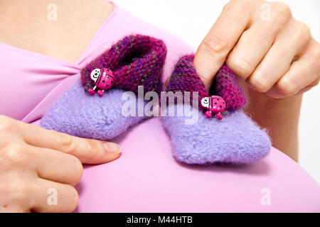 pregnant woman with babyshoes Stock Photo