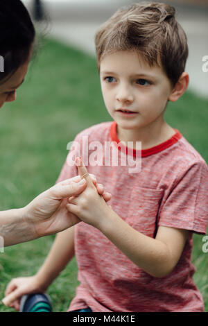 Mother looking at her son bleeding finger Stock Photo