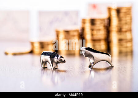 Bull and bear with stacks of coins and stock prices in the background Stock Photo