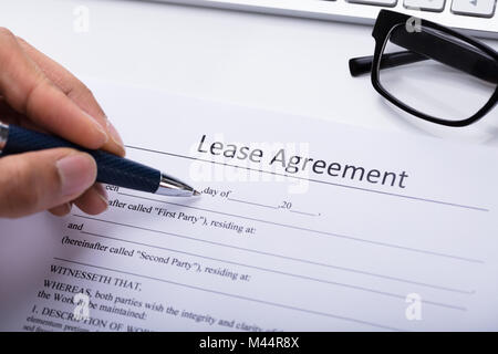 Close-up Of A Person's Hand Filling Lease Agreement Form Stock Photo