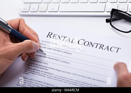 Close-up Of A Person's Hand Filling Rental Contract Form Stock Photo