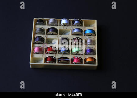 Box containing multiple spools of coloured cotton thread. Stock Photo