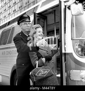 Extremely helpful bus driver gives personal close-up attention to a female passenger in Chicago, ca. 1963. Stock Photo