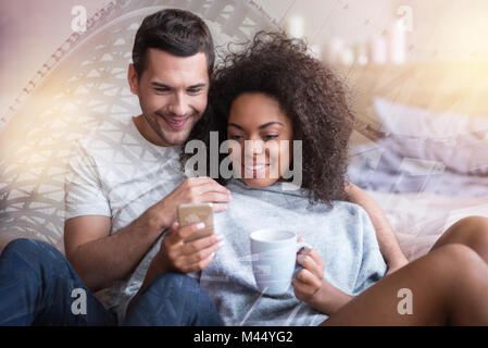Delighted nice woman using her smartphone Stock Photo