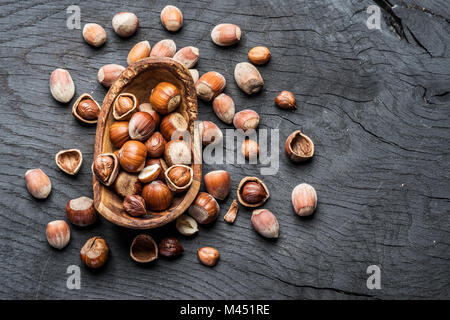 Filberts or hazelnuts in the wooden bowl on the table. Stock Photo
