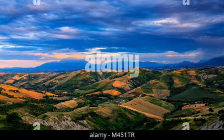 Hills overlooking  Majella group illuminated by the sun at sunset. Calanchi of Atri, Abruzzo, Italy. Stock Photo