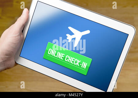 Man checking in to flight with tablet on the internet. Online check in with mobile device at home. Web self service provided by airline. Stock Photo