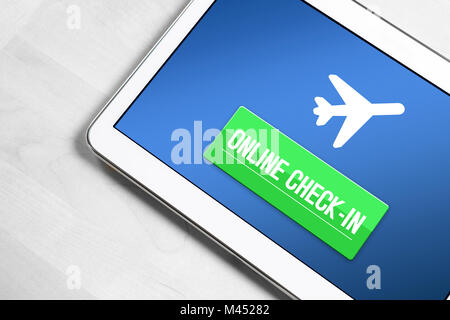 Online check in with tablet. Top view to mobile device on wooden table ready to checking in to flight on internet, web or application. Self service. Stock Photo