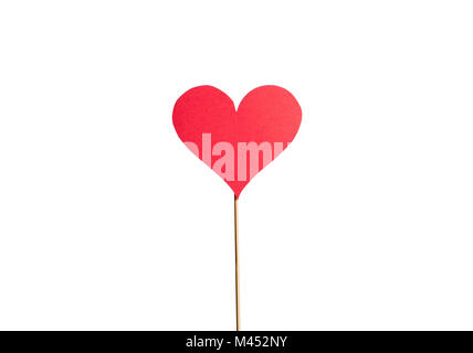 Cardboard heart on a wooden stick isolated on white background. Classic love symbol cut from paper. Red sign with papery texture. Simple design. Stock Photo