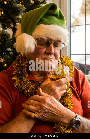 Man in Santa hat is trying to freshen the nip after alco party. He