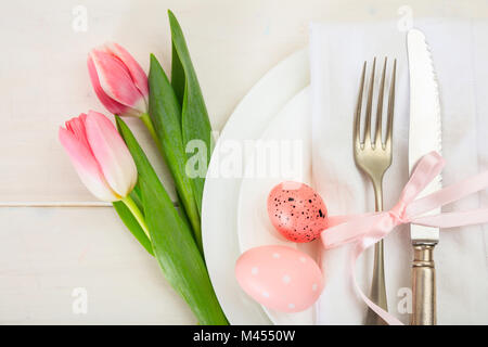 Easter table setting with pink tulips on white wooden background. Top view Stock Photo