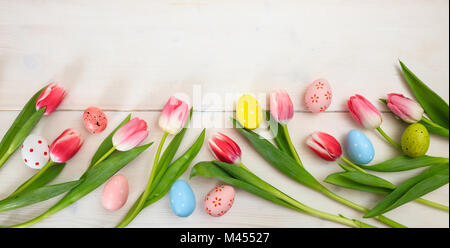Easter concept. Pink tulips and easter eggs on white wooden background, space for text, top view, banner Stock Photo