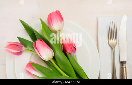 Valentines day table setting with pink tulips on white wooden background. Top view Stock Photo