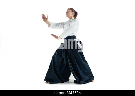 Aikido master practices defense posture. Healthy lifestyle and sports concept. Woman in white kimono on white background. Stock Photo