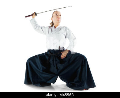 Aikido master practices defense posture. Healthy lifestyle and sports concept. Woman in white kimono on white background. Stock Photo