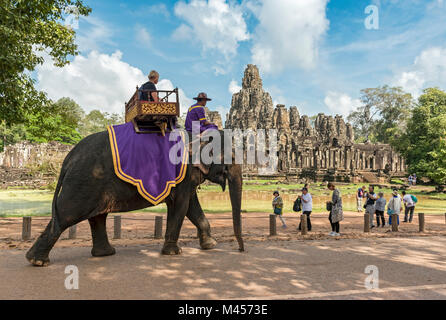 Tourist rides an elephant outside the Bayon Temple, Angkor Thom, Cambodia Stock Photo