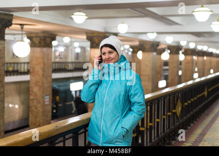 Woman talking on phone in Moscow metro in Russia Stock Photo