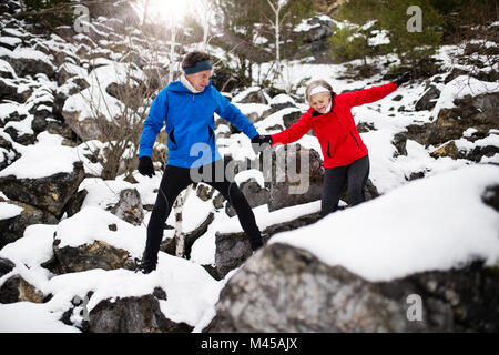 Senior couple jogging in winter nature.