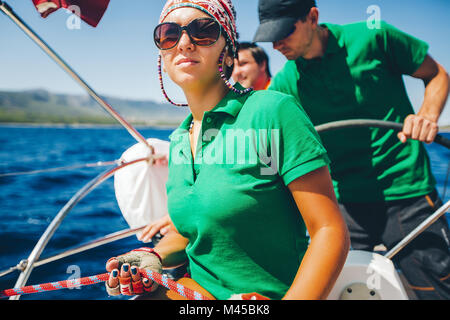 Young woman and men yachting near coast, Croatia Stock Photo