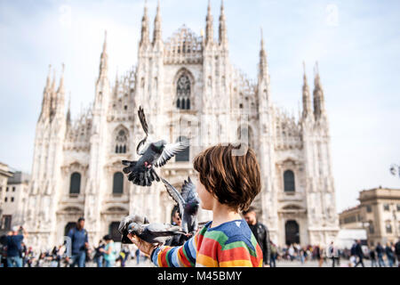 Boy feeding pigeons in Milan Cathedral square, Milan, Lombardy, Italy Stock Photo