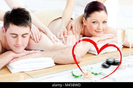 Composite image of attractive young couple enjoying a back massage Stock Photo