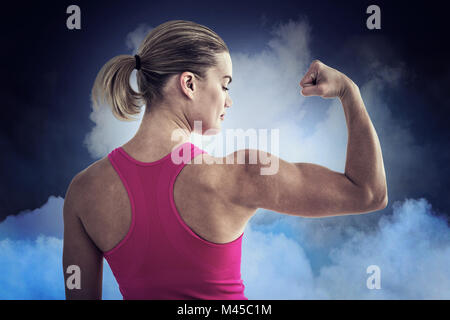 Composite image of rear view of muscular woman flexing muscles Stock Photo