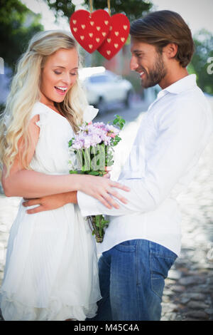 Composite image of attractive couple with bunch of flowers Stock Photo