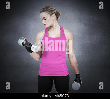 Composite image of muscular woman exercising with dumbbells Stock Photo