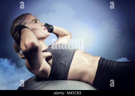 Composite image of muscular woman doing sit ups Stock Photo