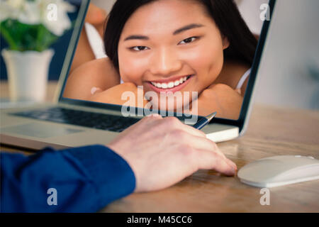 Composite image of businessman using laptop in office Stock Photo