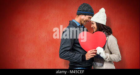 Composite image of festive couple in winter clothes Stock Photo