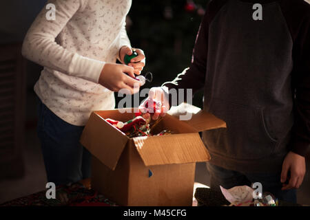 Brother and sister putting up Christmas decorations Stock Photo
