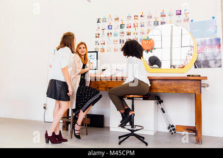 Colleagues in creative studio at desk having discussion Stock Photo