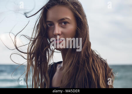 Portrait of young woman with flyaway long hair on beach, Odessa, Odessa Oblast, Ukraine Stock Photo