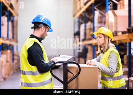 Young warehouse workers working together. Stock Photo