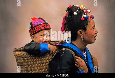 Laos. Luang Prabang. Mother with son in basket from Hmong hill tribe. Portrait. Stock Photo