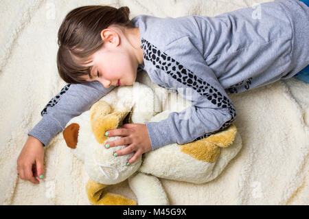 Girl taking a nap while hugging her toy Stock Photo