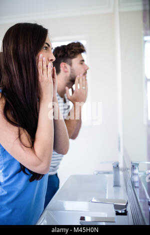 Young couple looking themselves in the mirror Stock Photo