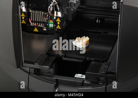Open 3D Printer With Finished 3D Printed Dental Implant Bridge. Stock Photo