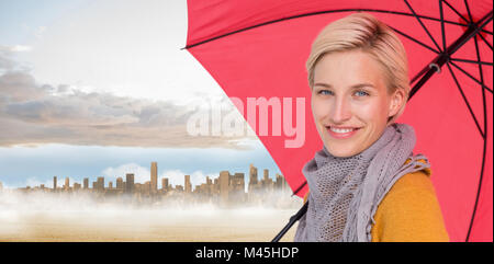 Composite image of smiling woman holding an umbrella Stock Photo