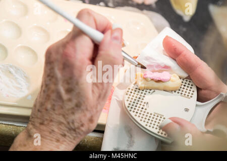 Female Dental Technician Applying Porcelain To A 3D Printed Implant Mold In The Lab. Stock Photo